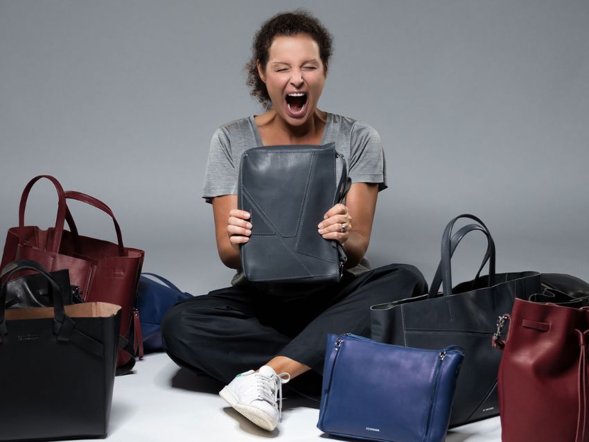 Frau sitzt und um sich herum viele schöne Ledertaschen