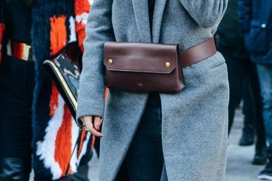 Frau im Mantel und brauner Leder-Gürteltasche