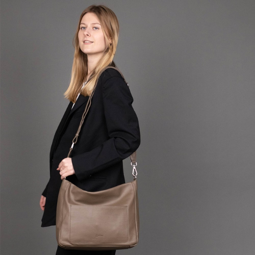 Frau von der Seite mit brauner Ledertasche über der Schulter