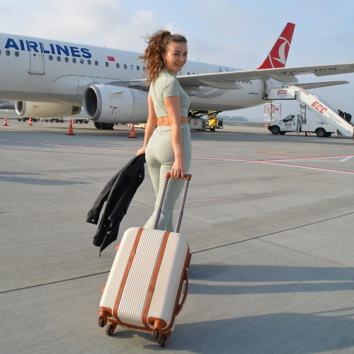 Trolley Beige Milano Frau geht zum Flugzeug