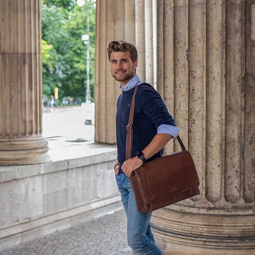 Leder Herrentasche in braun an Mann mit blauen Pullover und gestreiften Hemd auf Universitäts-Gelände