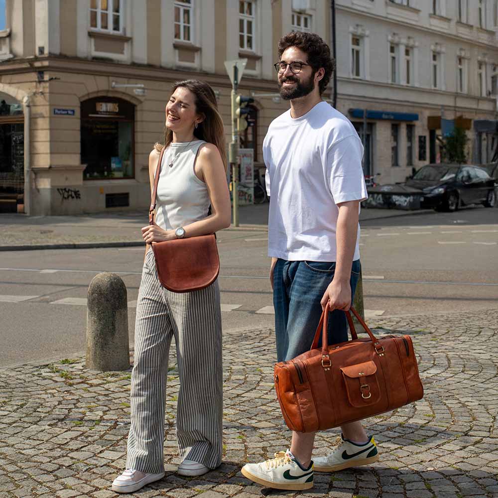 Mann und Frau sind in der Stadt mit Schultertasche und Reisetasche aus Ziegenleder