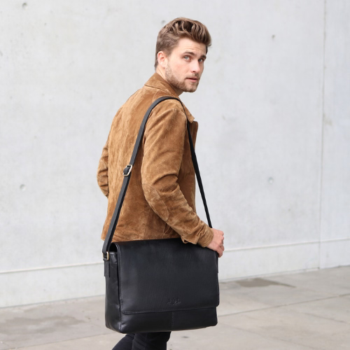 Mann stehend mit schwarzer Ledertasche über der Schulter