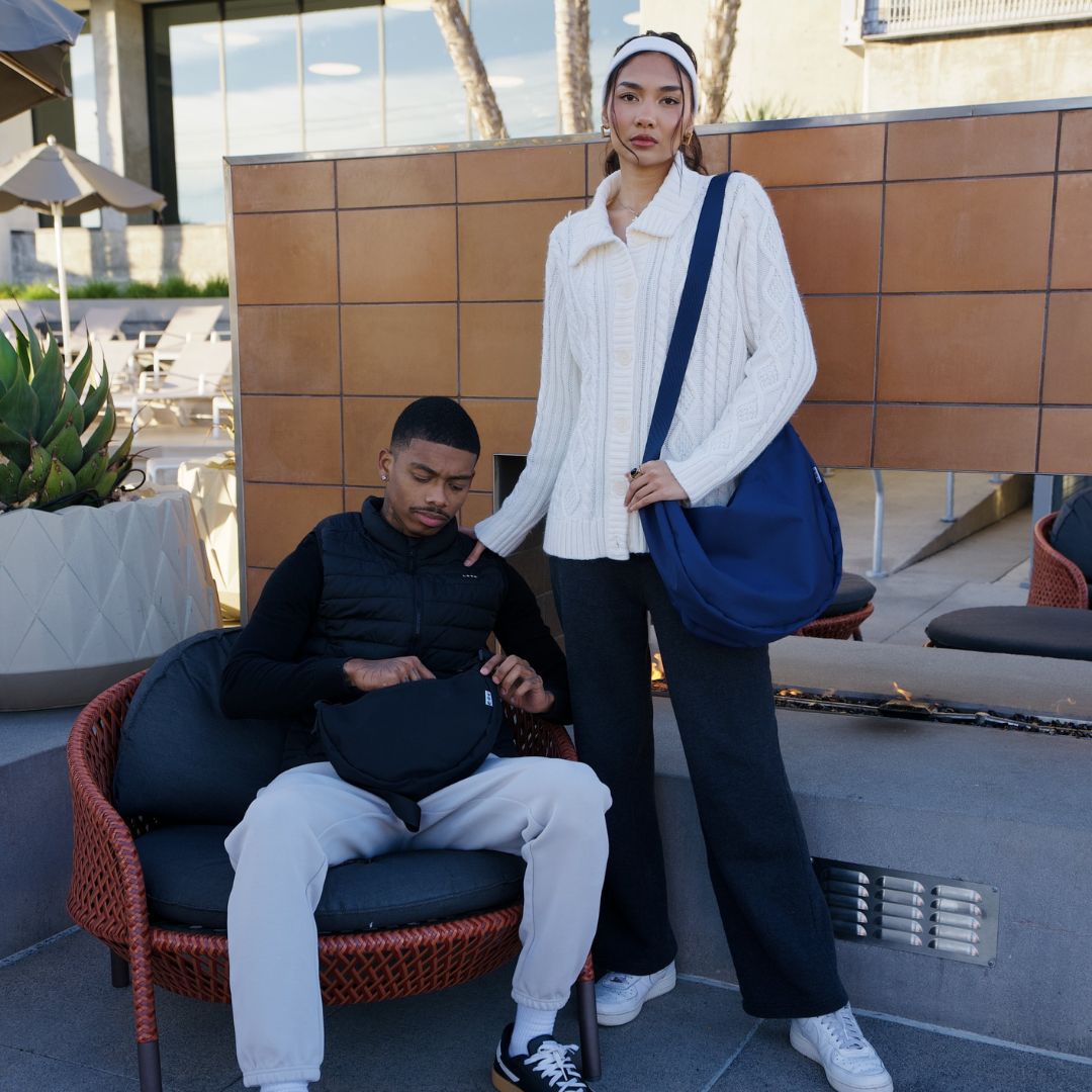 Moon Bag XL schwarz und blau Moodbild Outdoor Mann und Frau tragen weißen Pulli und schwarze Jacke