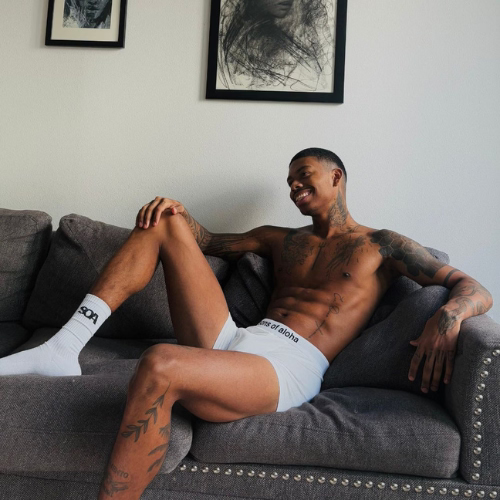 Mann liegt auf dem Sofa und traegt eine weiße Boxershorts mit weißem Bund