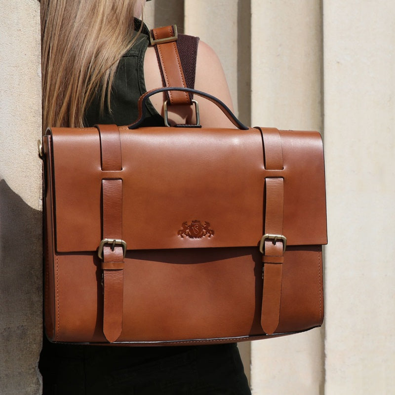 Nahaufnahme einer braunen Ledertasche, getragen von einer Frau