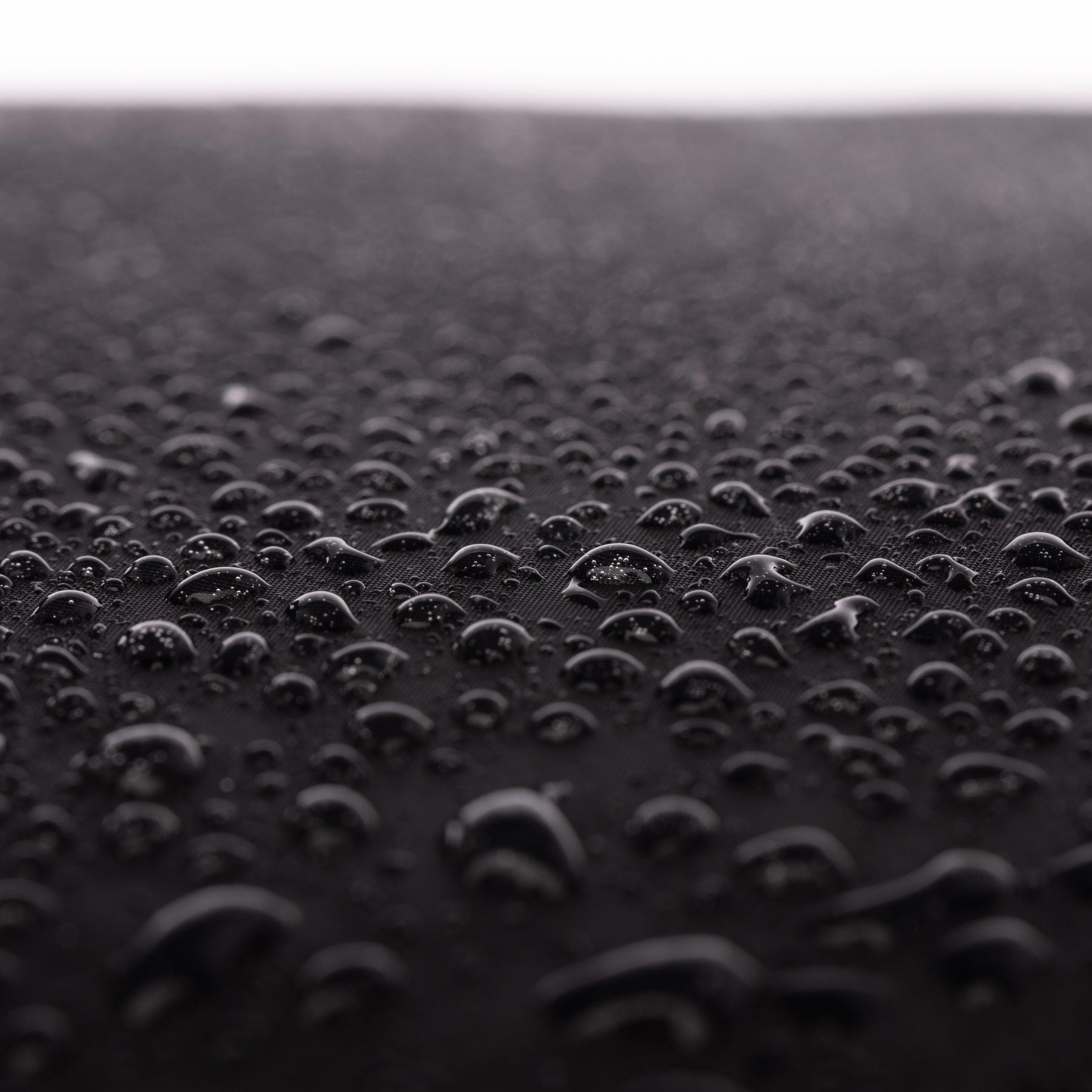 schwarzes Tarpaulin Closeup mit Wassertropfen