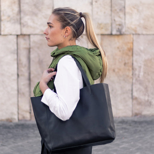 Studentin mit schwarzer Leder-Unitasche aus Glattleder auf dem Weg zur Universität