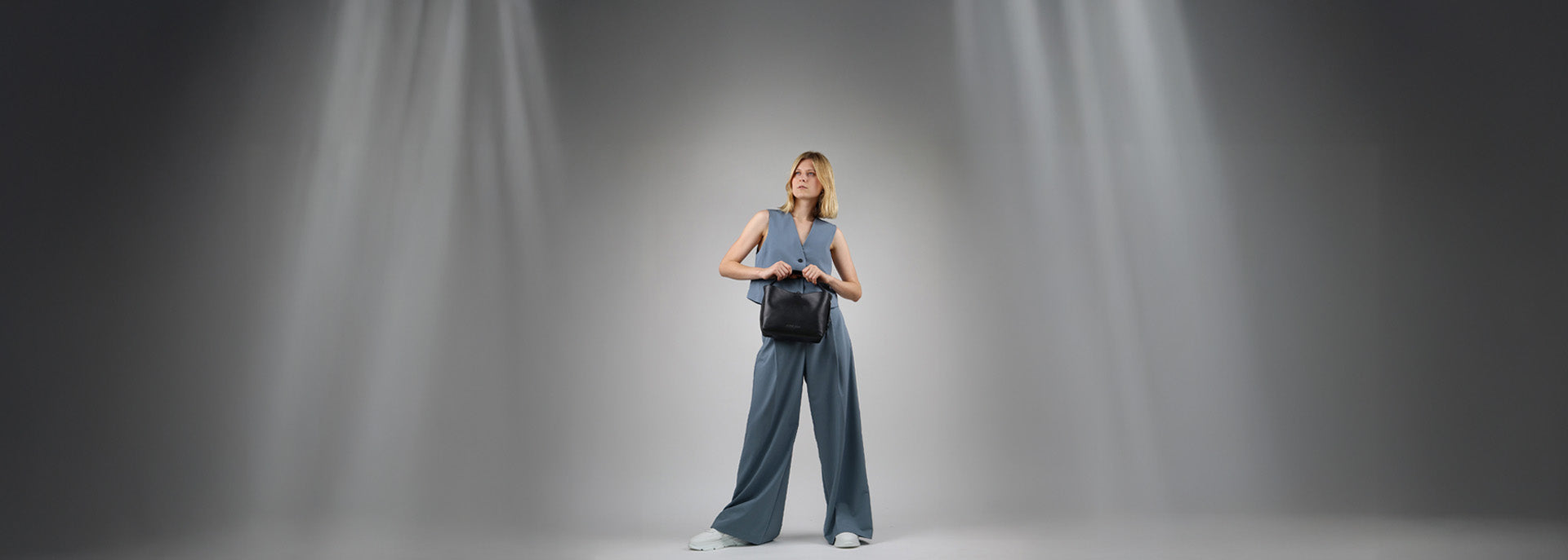 Feynsinn Ledertasche schwarz in Hand von blonder Frau im Studio