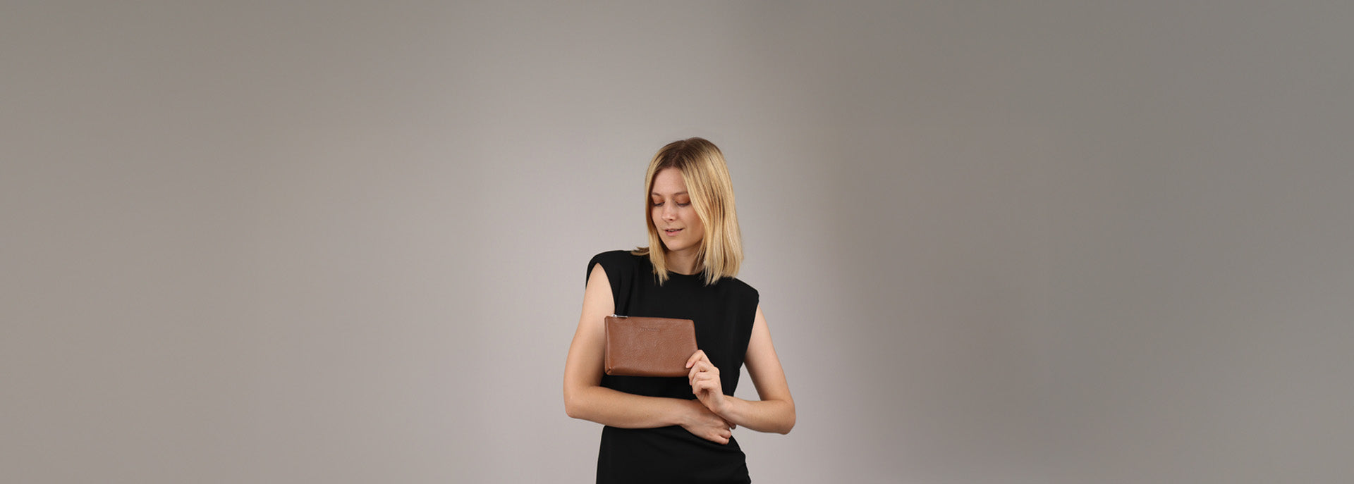 Kosmetiktasche aus Leder in Hand von Dame im Studio