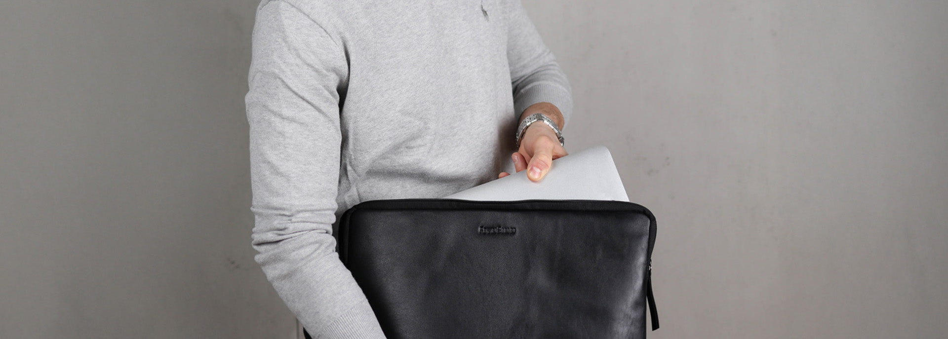 Mann mit Laptophuelle in schwarzen Leder