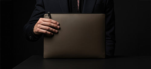 Wir sehen einen Manager in New York mit seiner Laptoptasche für Herren aus beigem Leder