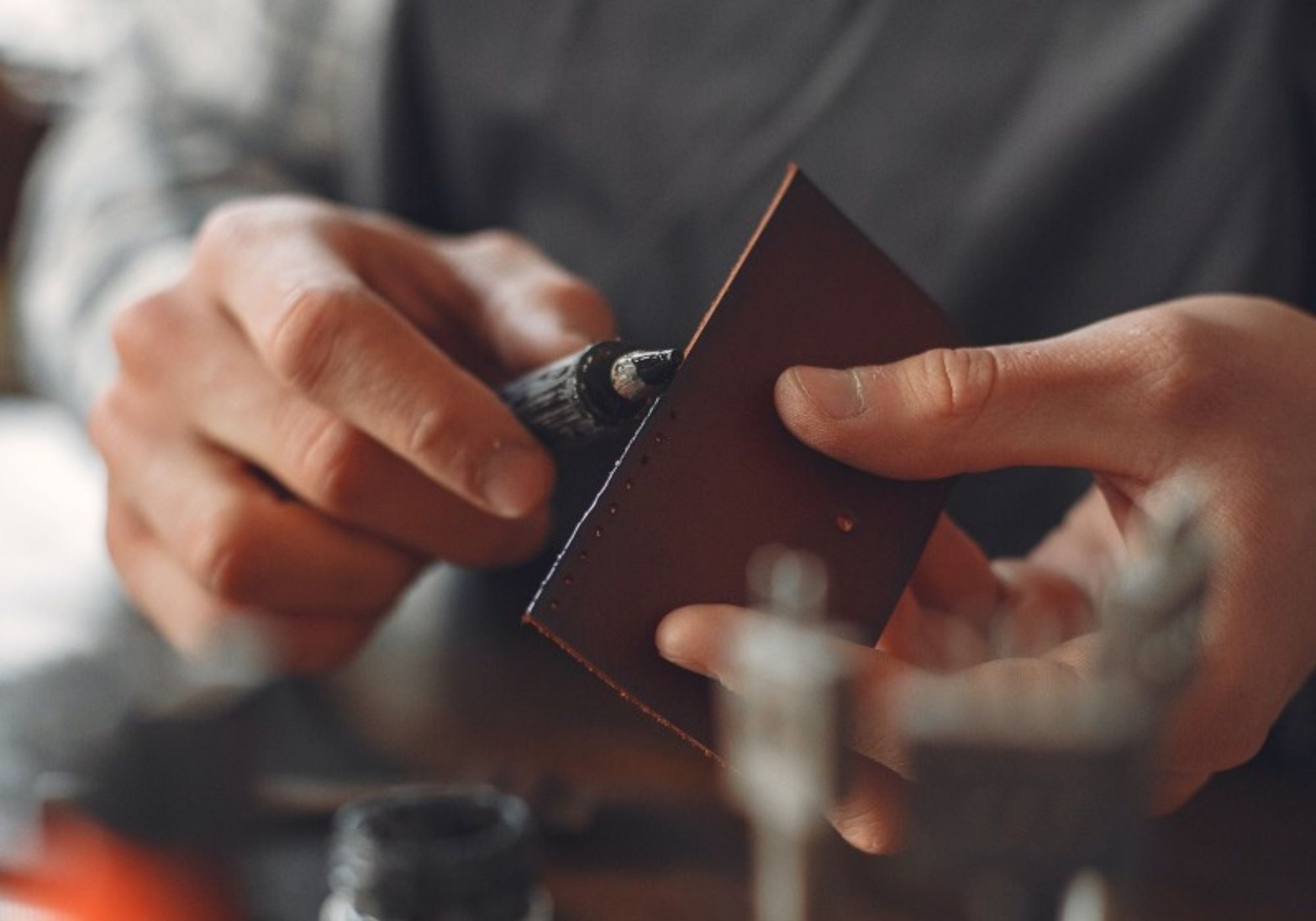 Reperaturservice Mybagfactory Mann arbeitet an einem Stück Leder