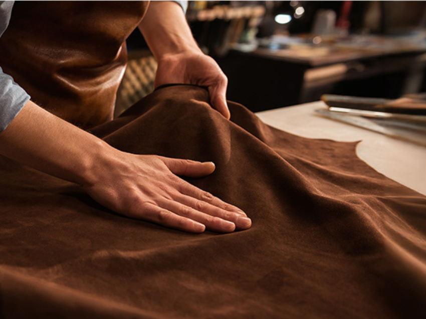 Ein großes Stück Leder wird von einem Mann bearbeitet