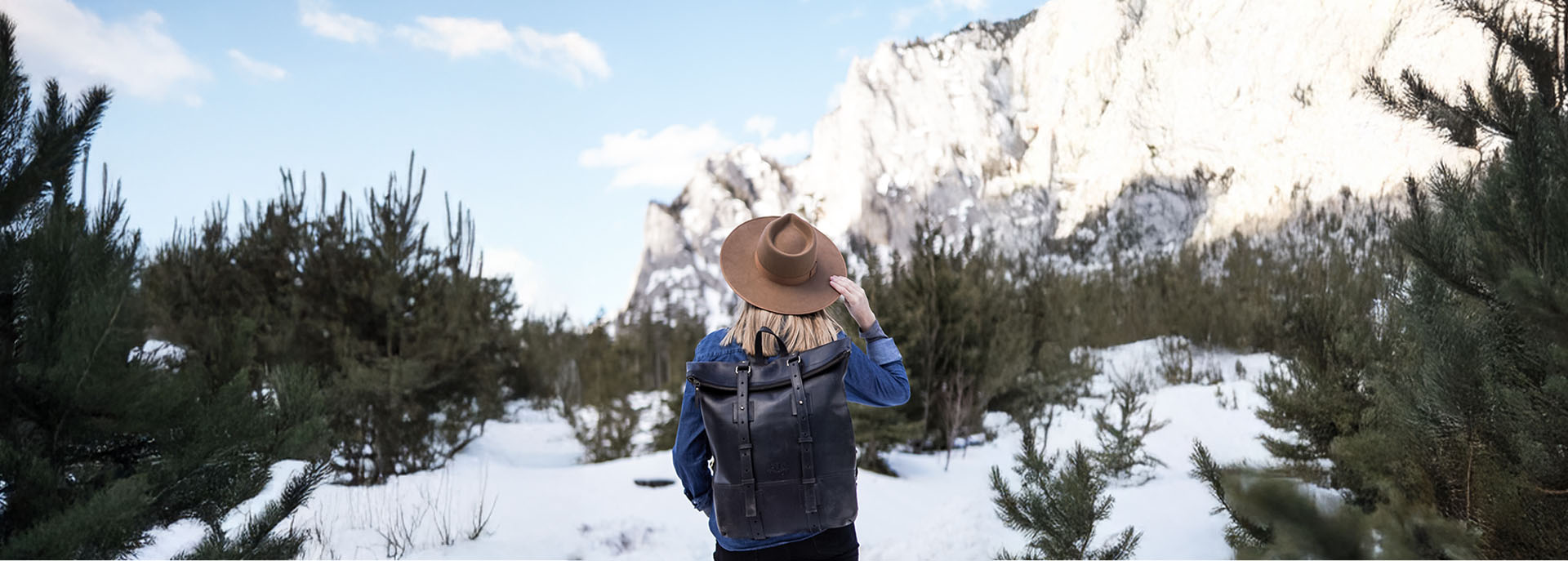Frau mit Lederrucksack in der Natur