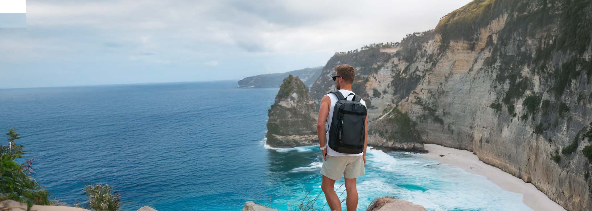 Reiserucksack AHI für Herren auf Rücken von Mann an Küste von Bali