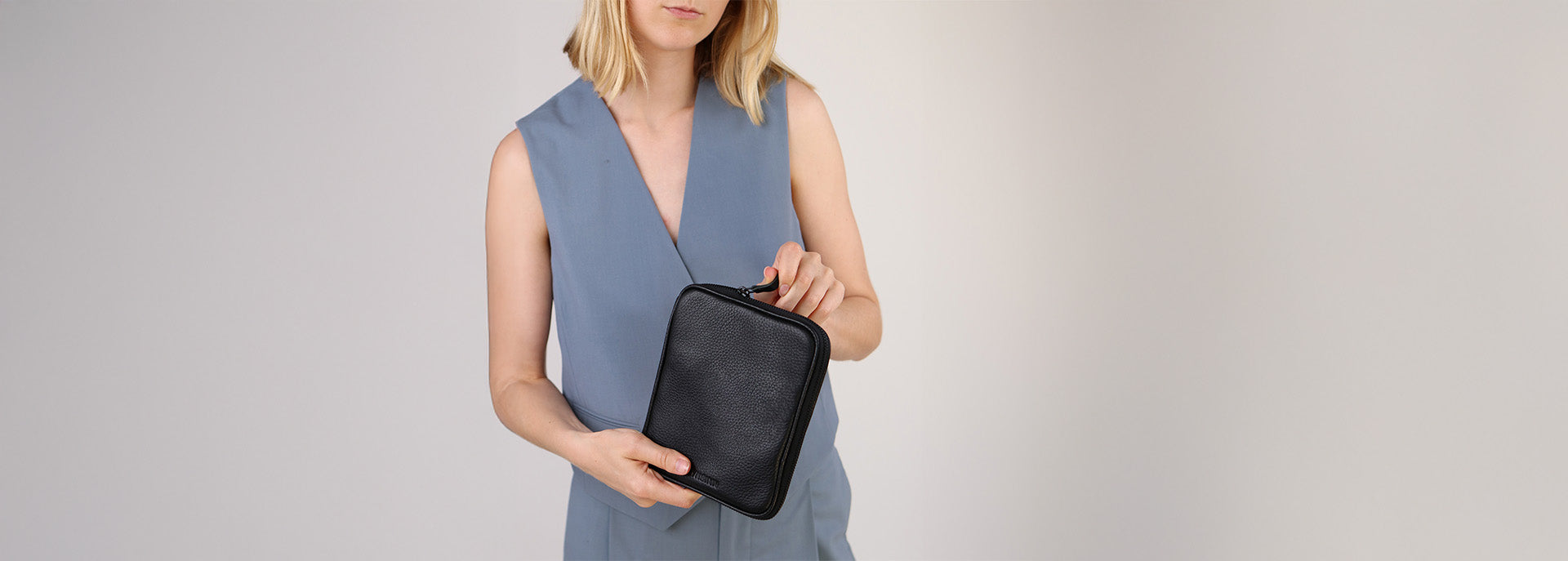 Frau hält Kabeltasche in schwarzen Leder