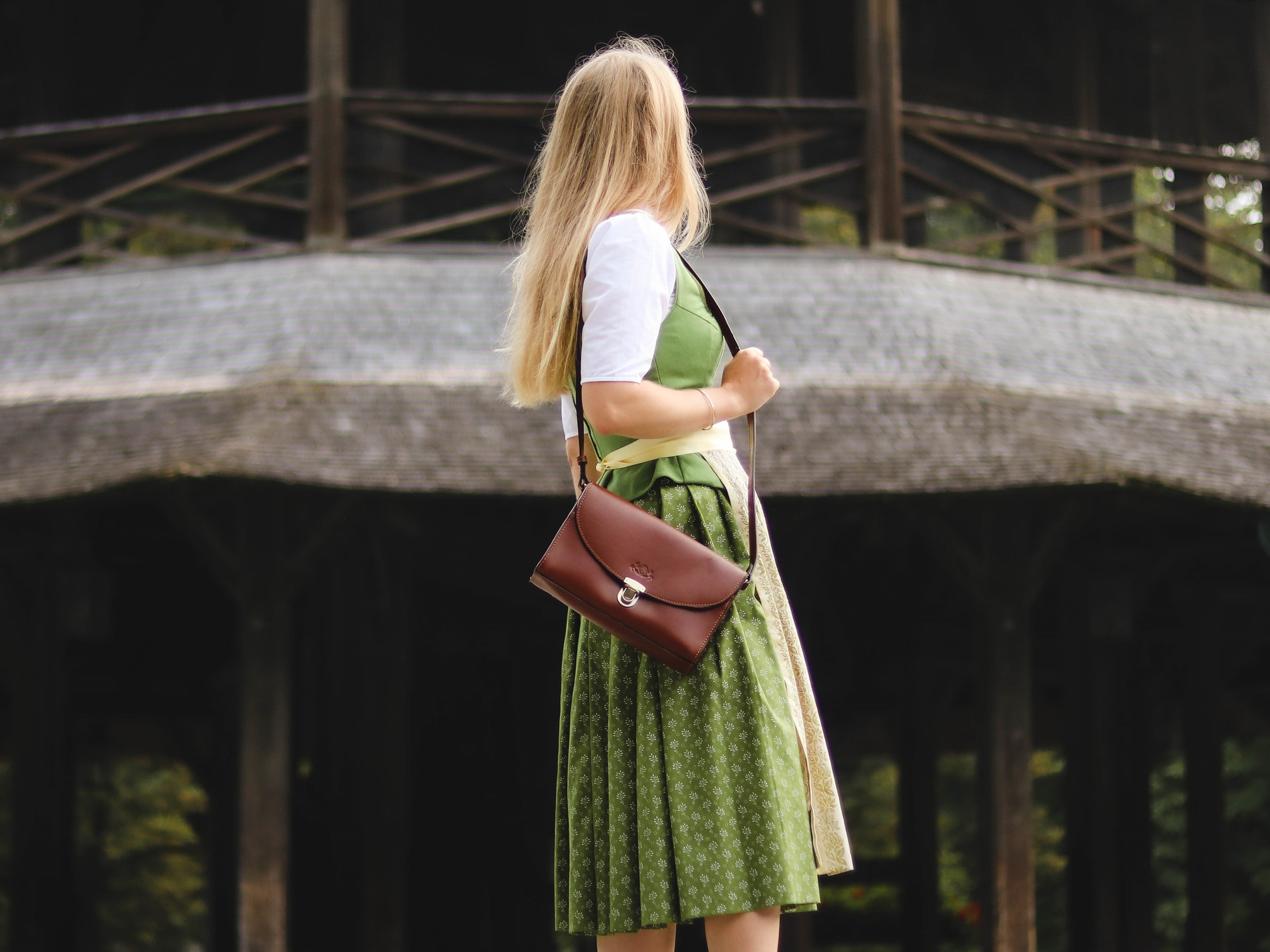 Frau mit Dirndl und brauner Ledertasche