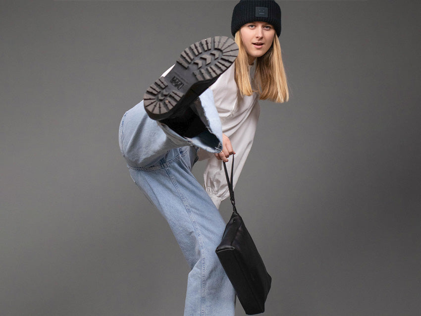 Model mit schwarzer Mütze und Lederhandtasche 