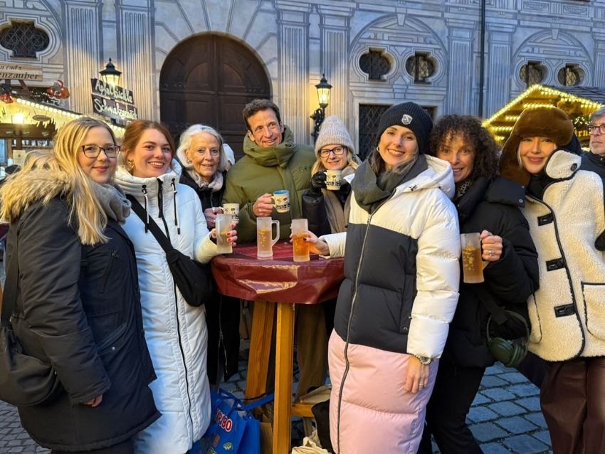 Eine Gruppe Personen an einem Tisch auf einem Weihnachtsmarkt