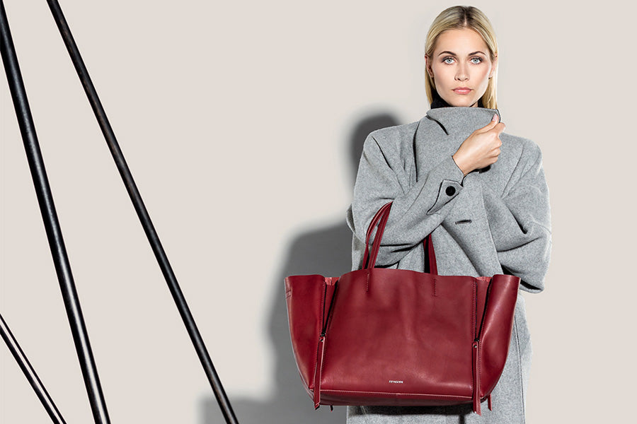 Frau mit roter Ledertasche posiert 