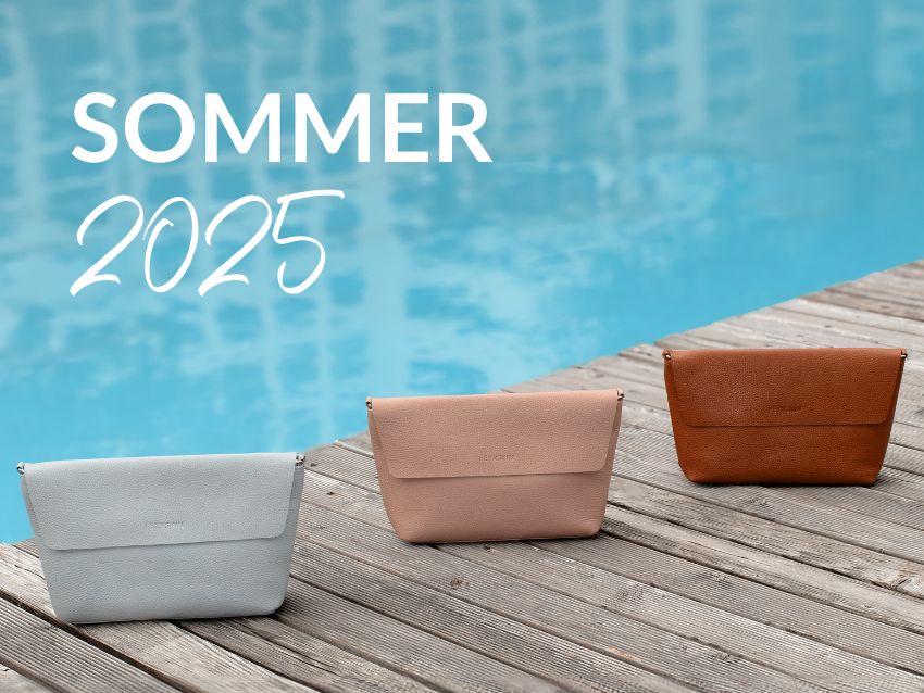 Nahaufnahme von drei Handtaschen in unterschiedlichen Farben an einem Steg mit dem Text "Sommer 2025"