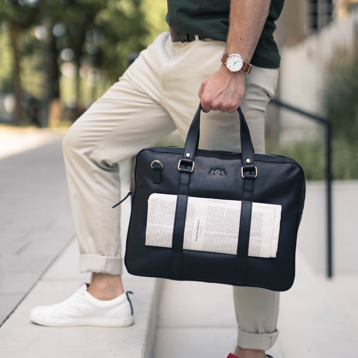 Laptoptasche schwarz in Hand eines Mannes Glattleder
