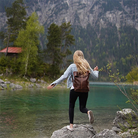 Damen Rucksack Leder Frau steht am See im Gebirge