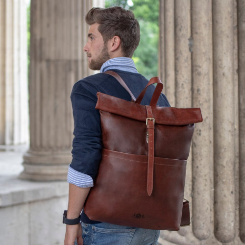 Mann mit Rücken zur Kamera, trägt einen großen braunen Lederrucksack.
