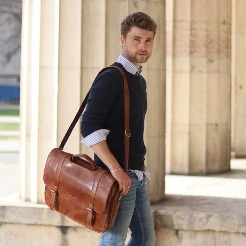 Mann mit brauner Ledertasche, stehend vor Säulen