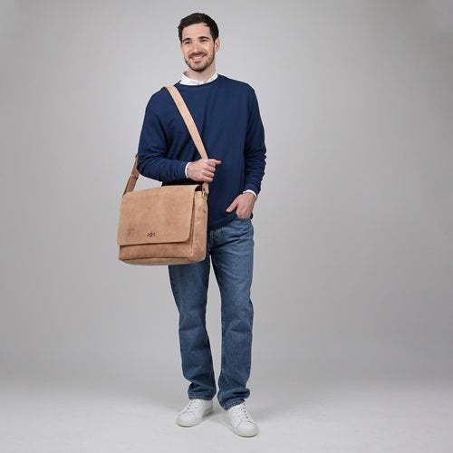 Mann stehend mit hellbrauner Ledertasche über der Schulter