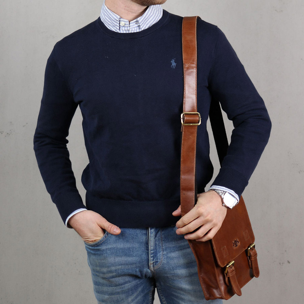 Umhängetaschen Herren aus Leder Studioaufnahme Mann traegt einen blauen Pulli und eine jeans