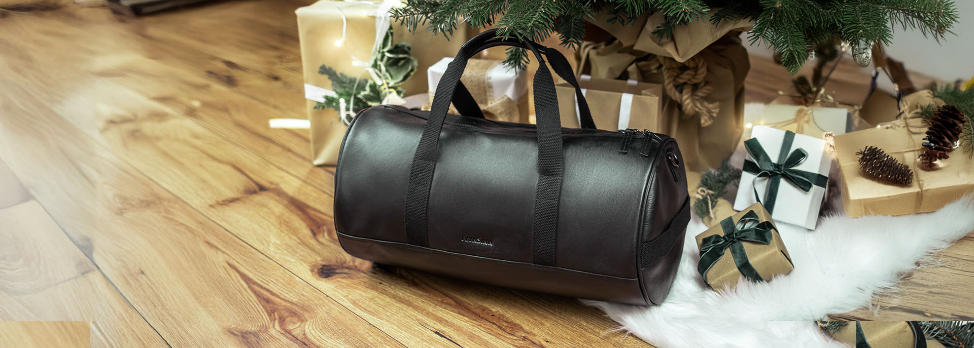 Geschenke für ihn Leder Reisetasche schwarz unter Weihnachtsbaum mit Geschenken
