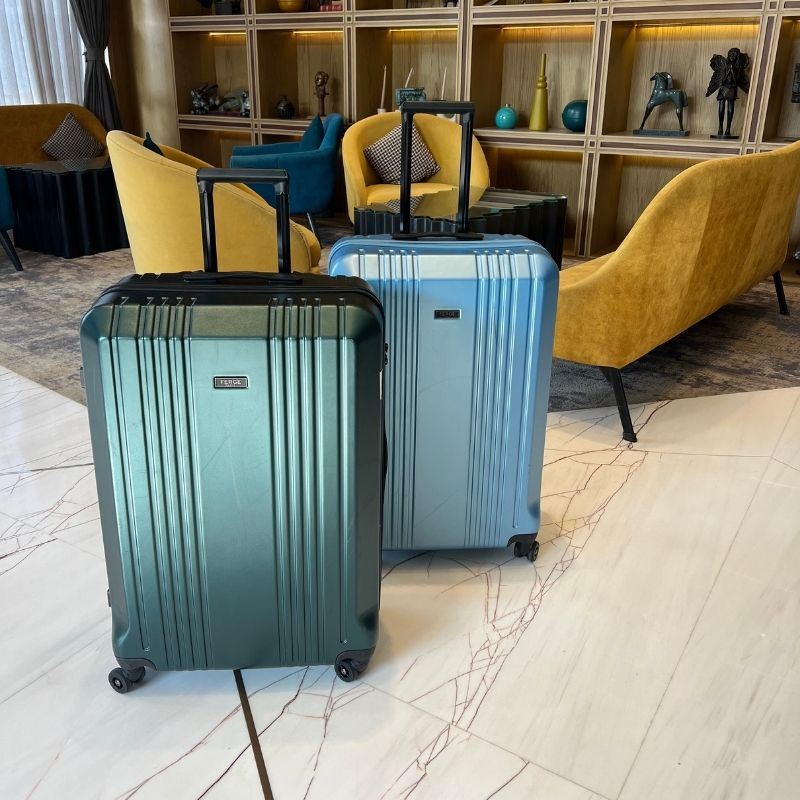 Hartschalenkoffer CANNES in smaragd gruen und oce blau in einer Hotellobby
