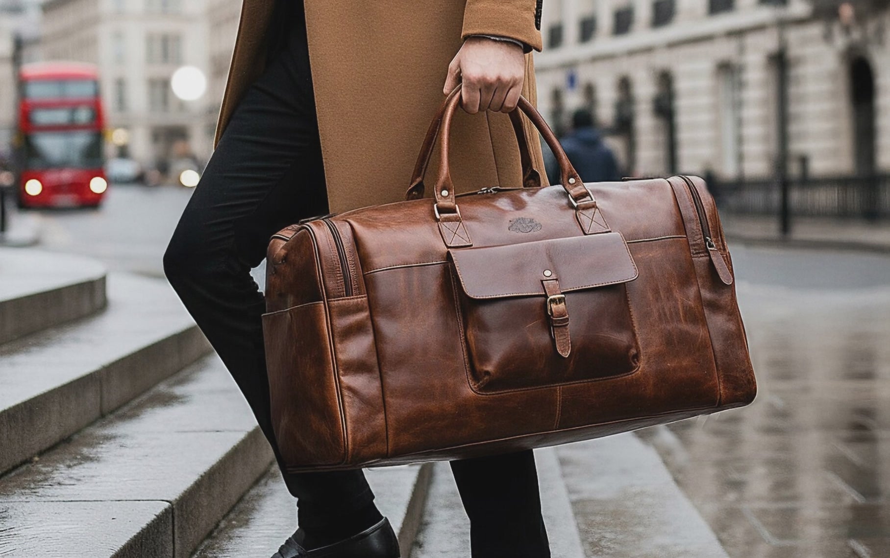 Cinematic wide shot of a stylish man ascending a series of glistening wet stone steps, coffee cup in one hand and a chic brown leather trave bag in the other. The bustling cityscape buzzes with blurred figures and a striking red double-decker bus, amplifying the energetic urban vibe. 