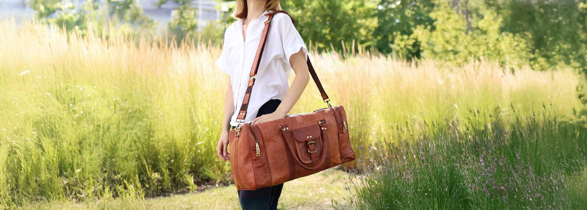 Frau mit brauner Ziegenleder Reisetasche XL im Feld