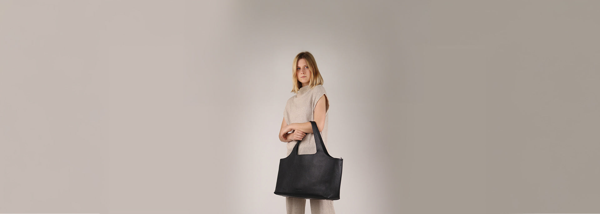 Studiobild von Frau und Shopper aus Leder in schwarz 