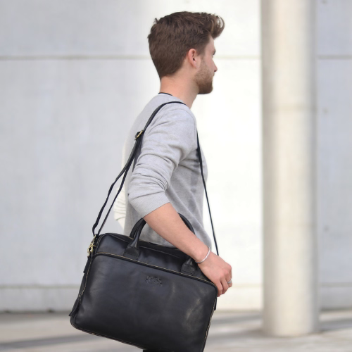 Mann von der Seite mit schwarzer Ledertasche über der Schulter