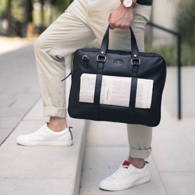 Sid & Vain Laptoptasche schwarz aus Leder Modell Maquire Mann traegt eine beige Chinohose
