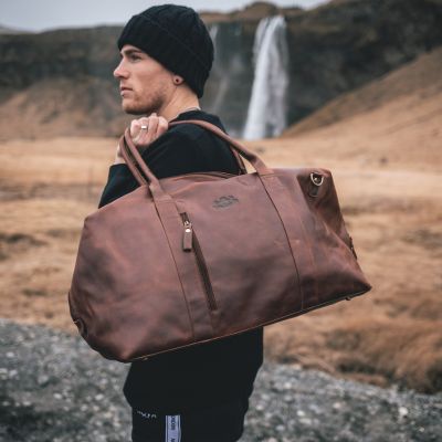 Sid and Vain Reisetasche Leder braun Mann traegt eine schwarz Mütze und einen schwarzen Pulli
