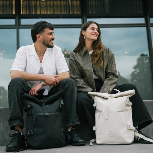 Uni Rucksack Herren in beige und schwarz Mann und Frau sitzen vor einer Uni